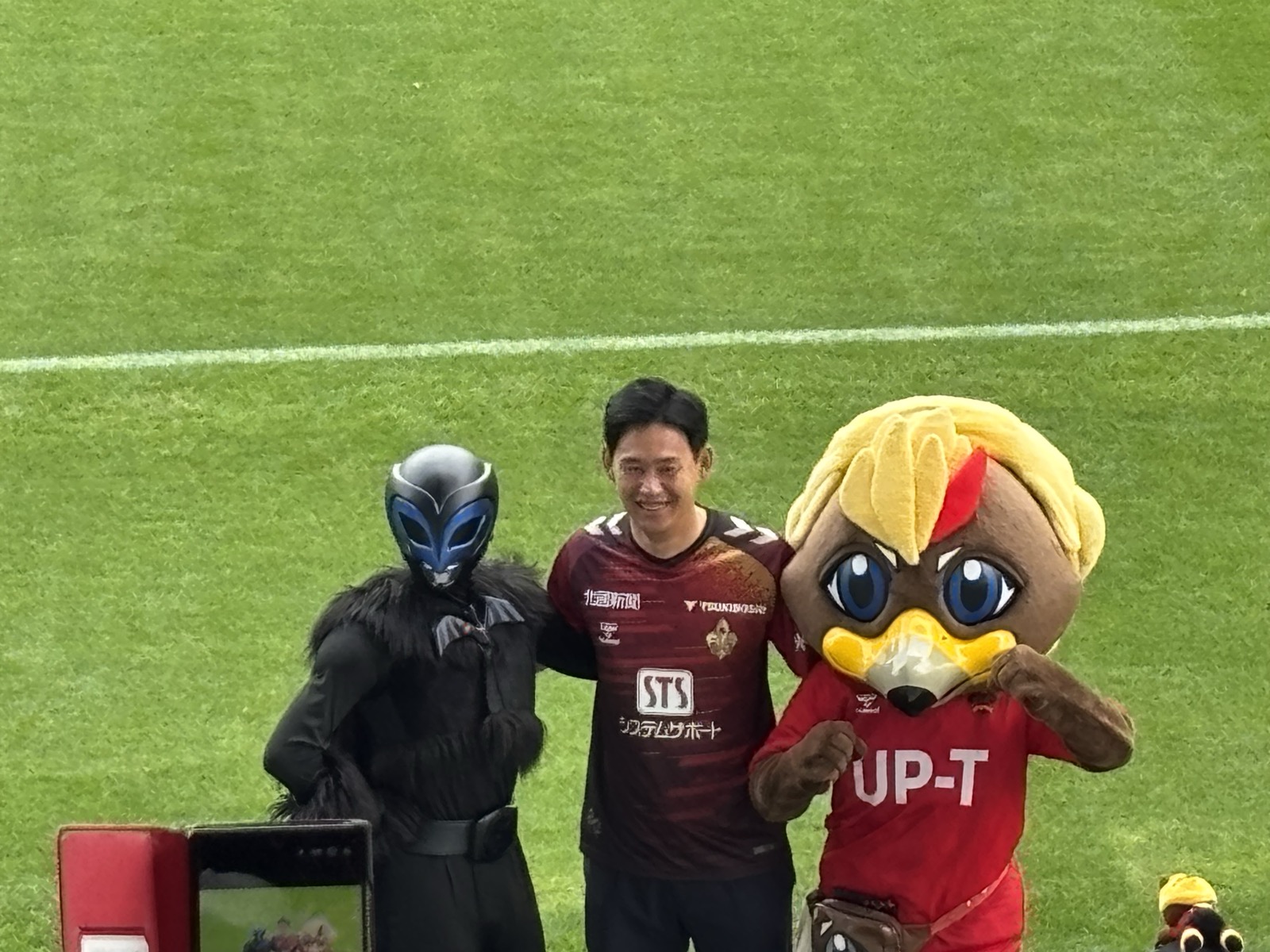 試合前ピッチで並ぶヤサガラス、佐藤洸一さん、ゲンゾー