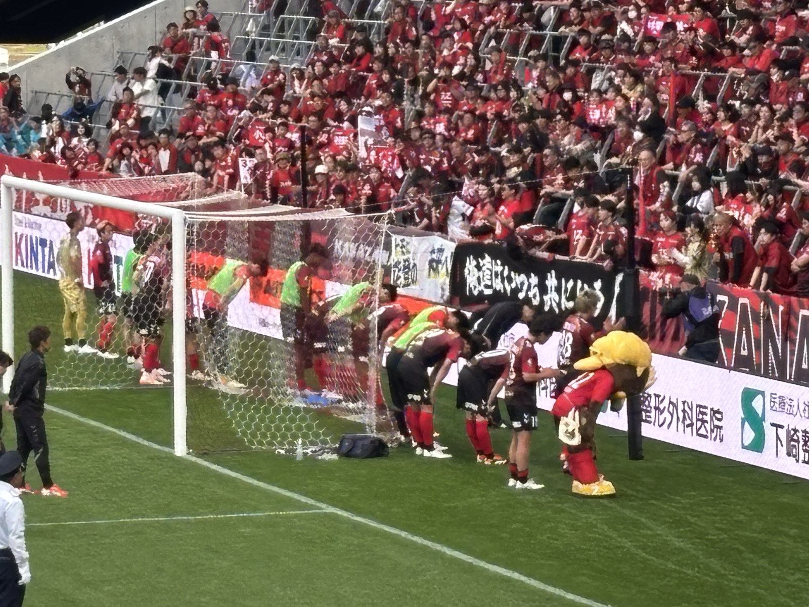 試合後、ホームサポーターに頭を下げて挨拶するツエーゲン金沢の選手たちとゲンゾー