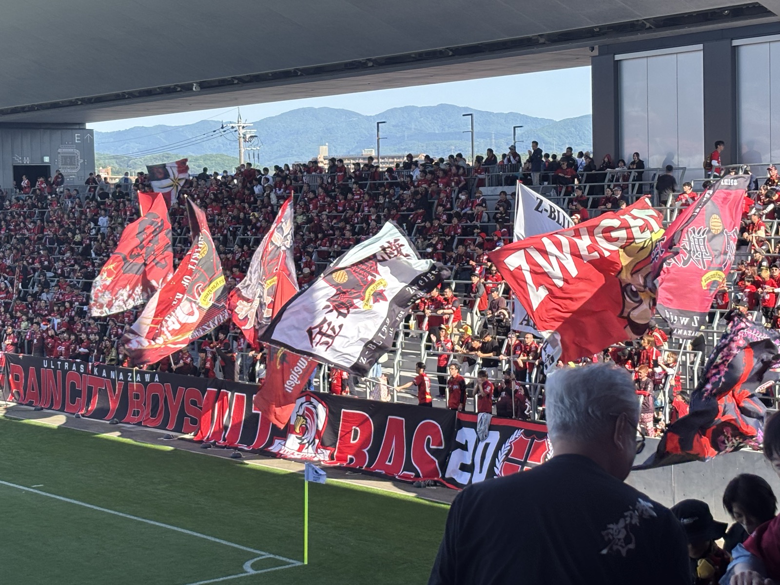 満員のホーム金沢サポーター席で揺れるZWEIGEN大旗・Ultras Kanazawa・Rain City Boys