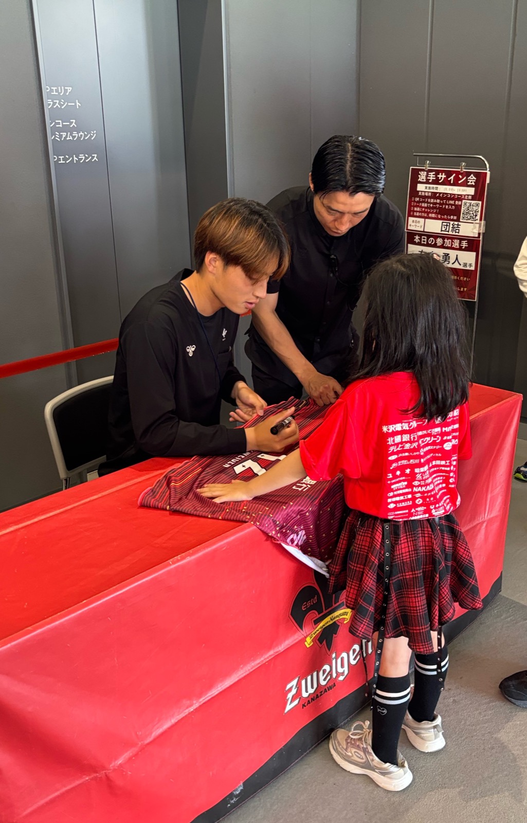 FW7 有吉勇人選手のサイン会 子供サポーターのユニフォームに丁寧にサインを入れる