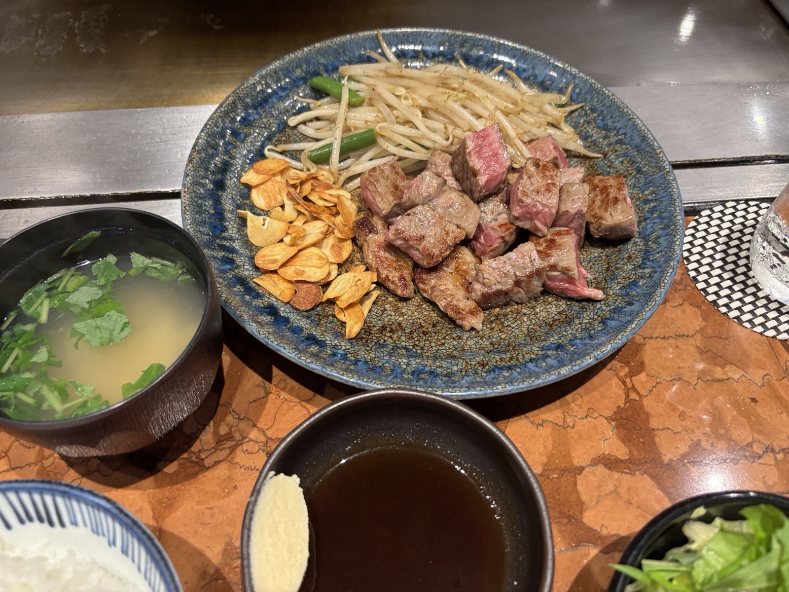 鉄板で焼き上げたステーキとガーリックチップ