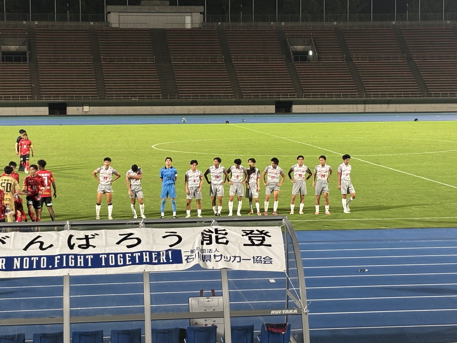 試合終了後ピッチに整列するツエーゲン金沢と金沢星稜大学の選手たち