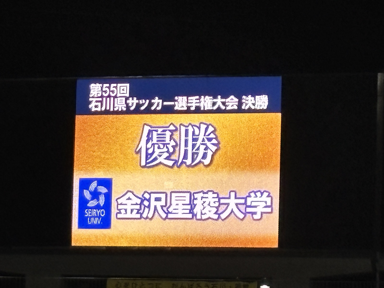 大型ビジョンに表示された第55回石川県サッカー選手権大会決勝 優勝金沢星稜大学の表示