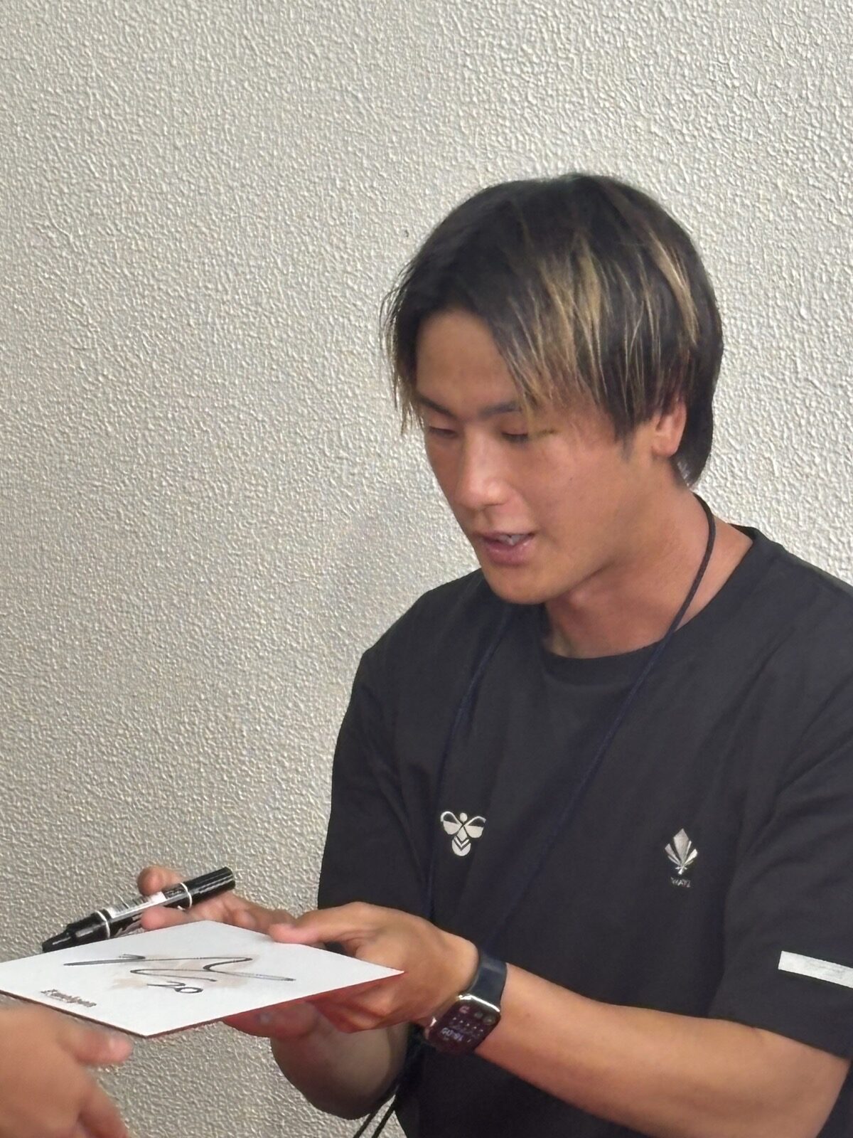 試合前ファンにサインを書くツエーゲン金沢の長倉颯選手