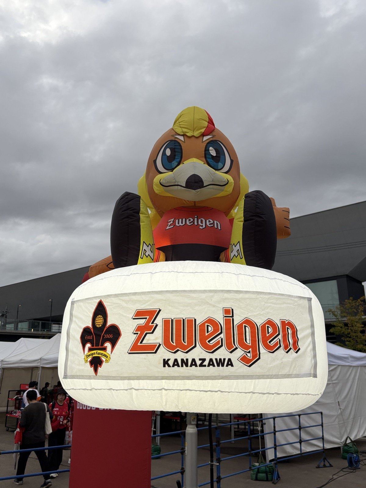 Zweigen KANAZAWAのロゴを抱えたゲンゾーの大型バルーン
